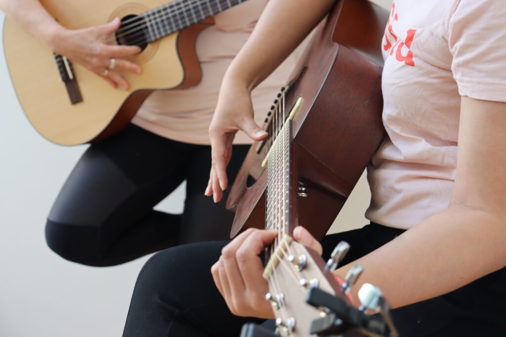 Two people playing guitar