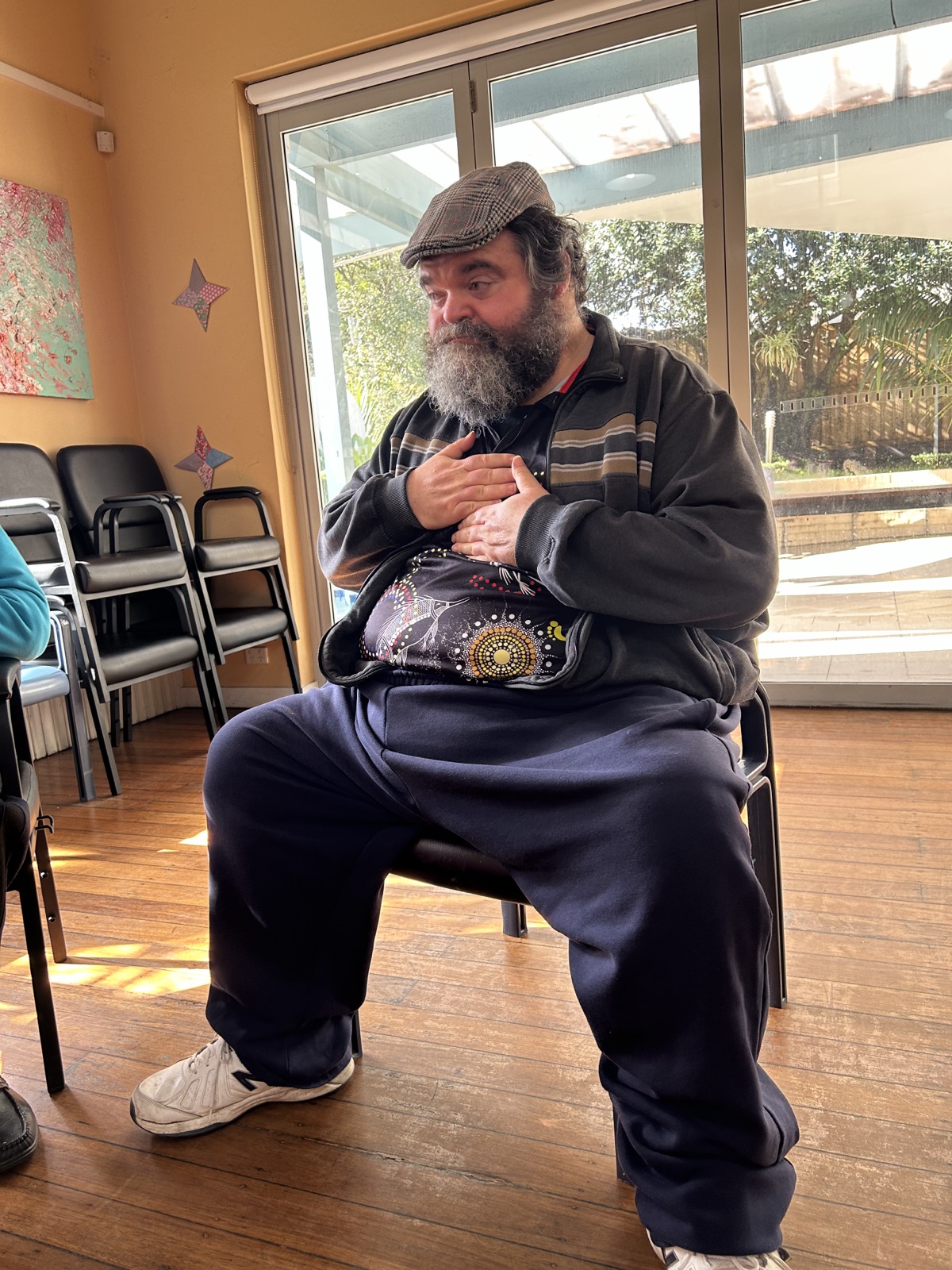 A participant resting one hand on his heart and one on his belly during a breathing practice